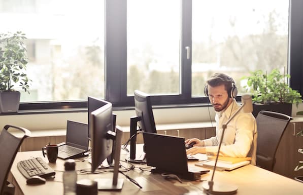 man of his computer with head phones